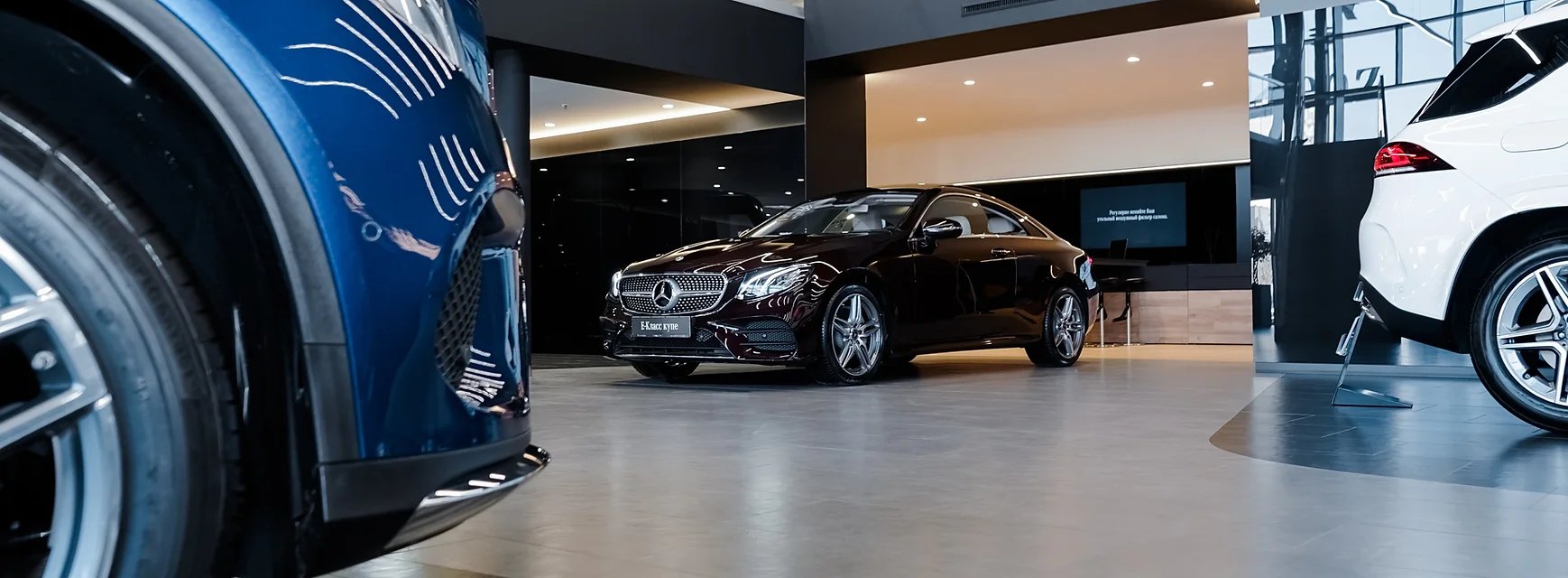 Black Mercedes-Benz coupe in modern, sleek car showroom